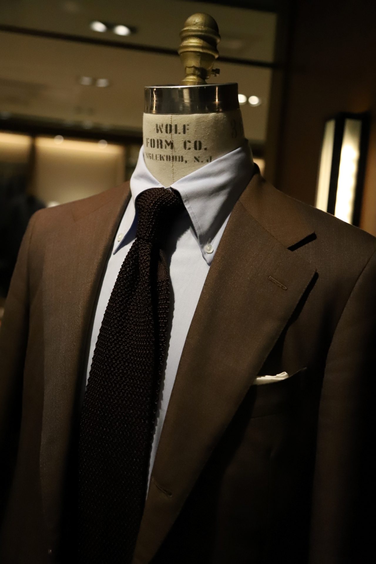 ボリエッロ（BORRIELLO）のネイビーのオーダーシャツとブラウンのオーダースーツ、アット ヴァンヌッチAtto Vannucci）のブラウンのニットタイを合わせたコーディネートです。スーツはTHE G'S HIDEOUT.オリジナルの1着です。